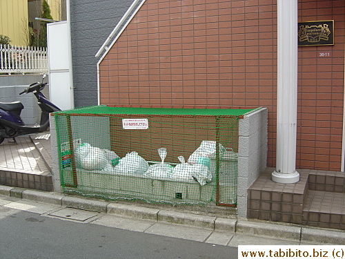 This apartment building has a built-in trash bay with a net