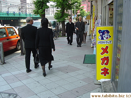 Looks like they are going to a funeral, the woman even wears black gloves to go with her all-black outfit