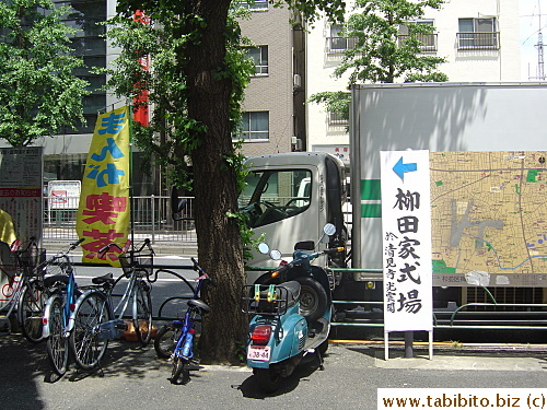 Another sign that tells people where the funeral's being held. (The blue, red and yellow banner advertises for a comic books caf)