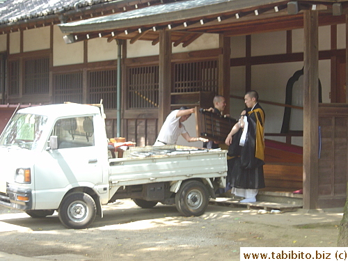 A couple of acolytes help with moving furniture in the temple