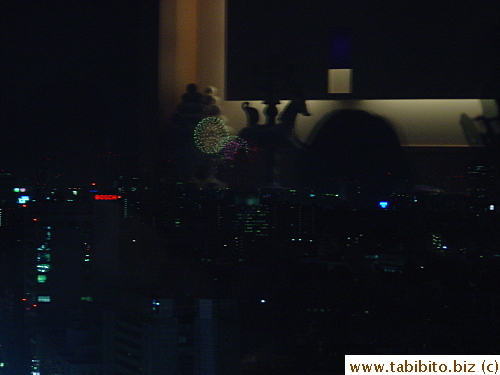 The beginning of the fireworks display. It's hard to capture the image with low light in the restaurant, the distance from the camera and the reflection on the window