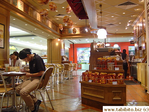 A staff in the café working on something on one of the tables