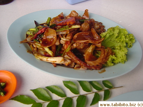 A stir-fried squid dish, not very tasty.  The leaves by the plate is a herb often used by the locals which has a very pungent taste