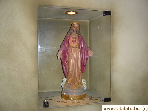 A Jesus statue embedded in the wall of the hallway 