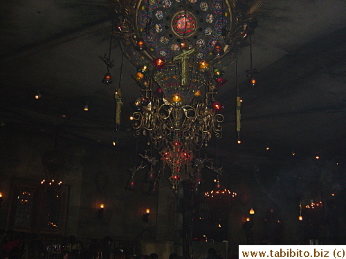 One of several hugh gaudy chandeliers with crosses hang from the ceiling