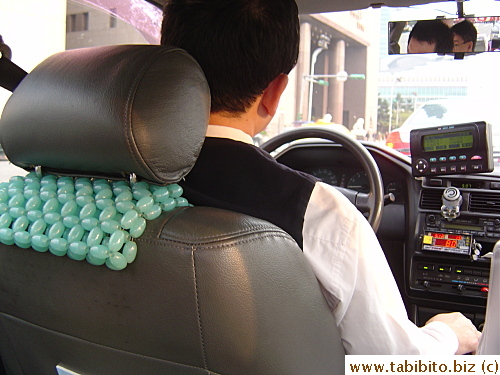 Our first taxi driver. Notice his beaded seat cover, similar to those used by Hong Kong cabbies