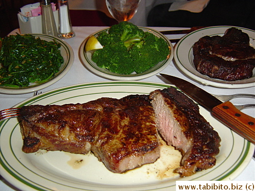 My enormous rib eye (medium well).  Note the normal-size fork becomes pint-size against the giant steak.  The knife is double the size of a dinner knife and still looks small next to the steak