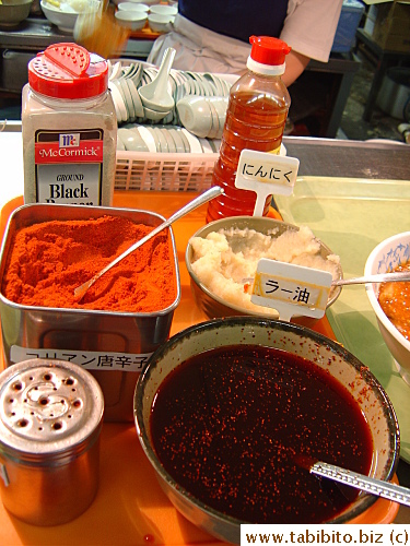 Chili sauce and powder etc are provided on the kitchen counter for people to put on the noodles.  The bowl of mashed potato-like thing is grated raw garlic.  One teaspoon of that stuff will render your breath stinky for the rest of the day