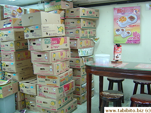 Boxes of mangoes stacked all the way to the ceiling inside the restaurant