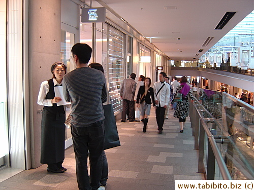 Properly attired staff try to sell their swanky restaurants to potential customers 