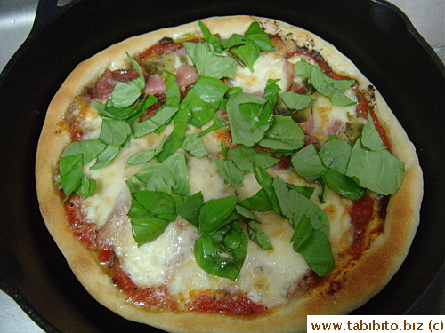 Fresh basil completes the pizza