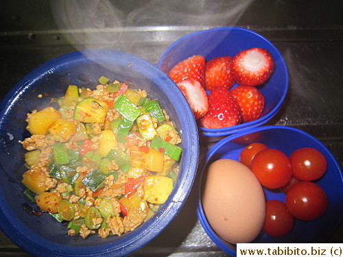 Spicy minced pork with veggies over rice, hardboiled egg, cherry tomatoes, strawberries