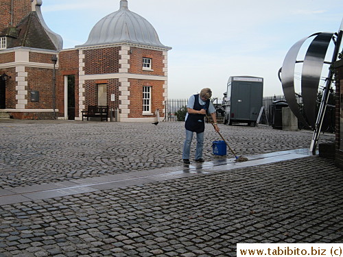 A staff cleans it before the horde of tourists waiting to get in