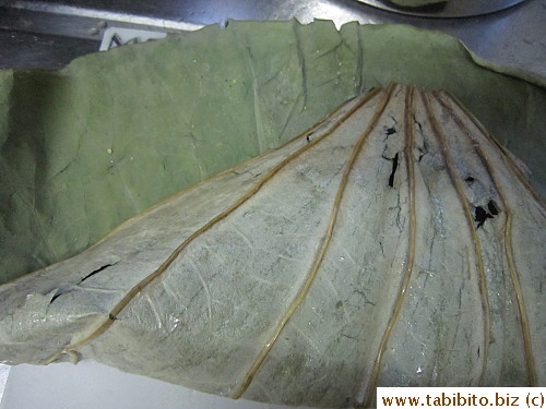 Start folding the end bit to cover the rice