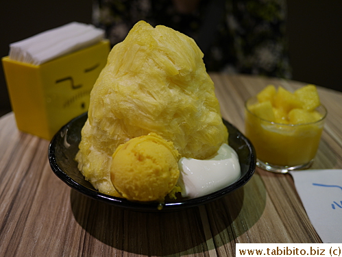 Gigantic bowl of mango shaved ice with mango ice cream and almond tofu (?) and fresh pineapple in syrup
